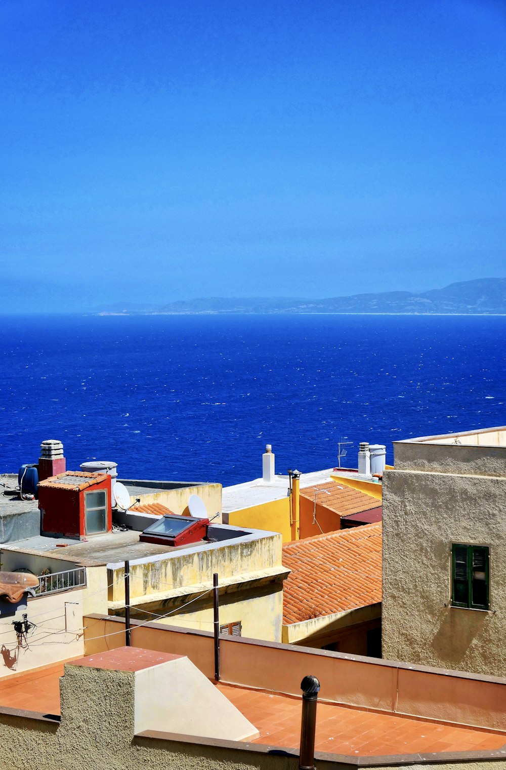 brown concrete houses near sea during daytime