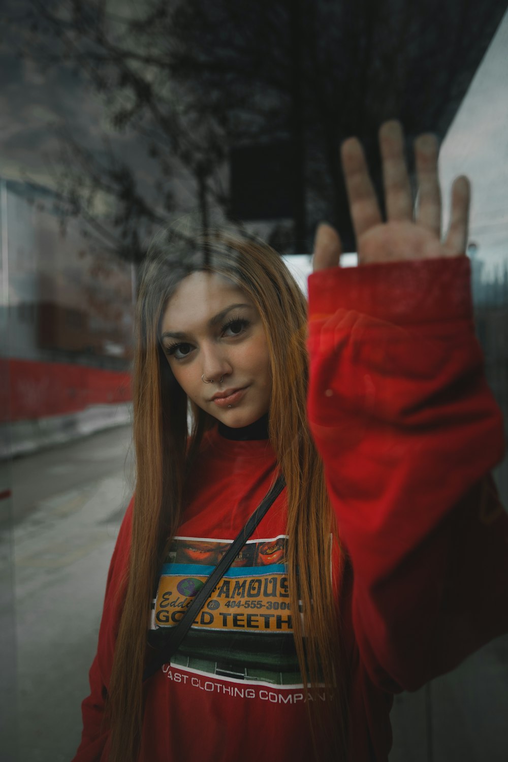 woman in red coat standing near glass wall