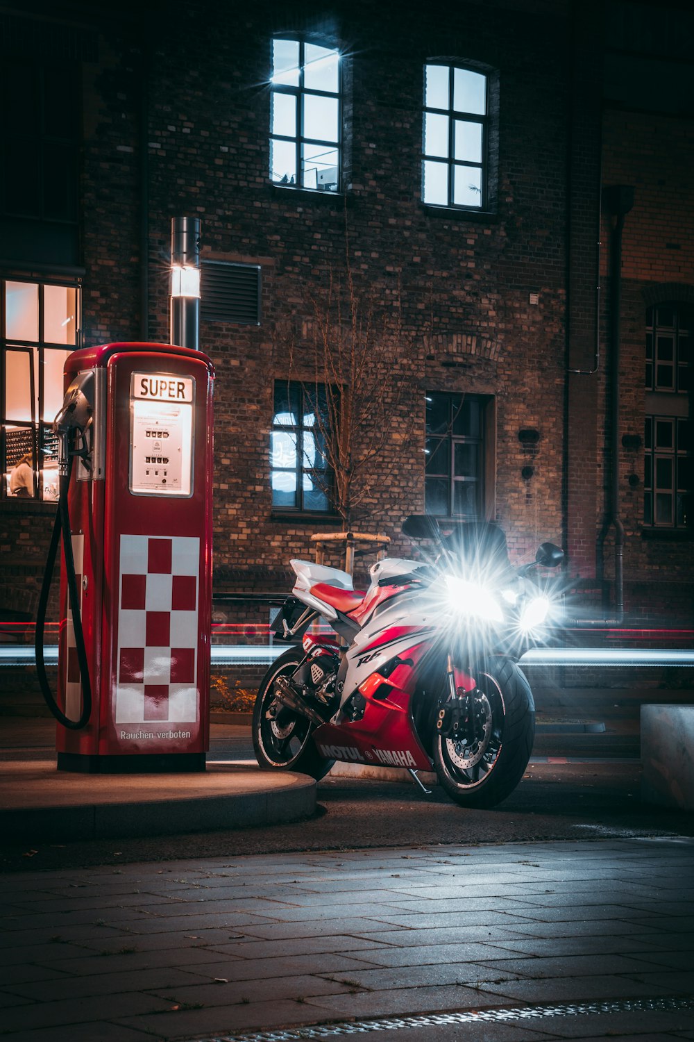 black motorcycle parked beside red and white fire extinguisher