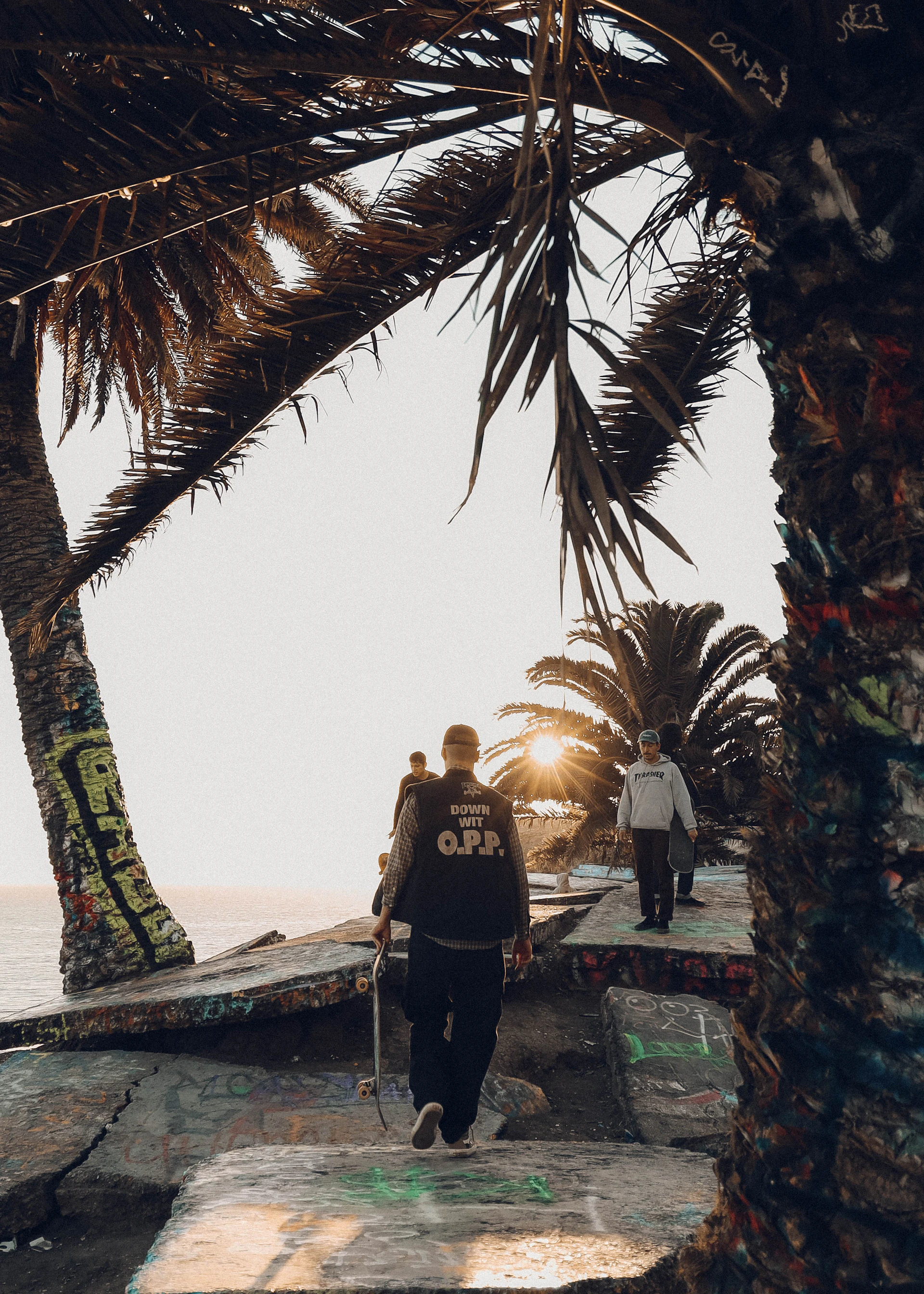 A group of friends laughing and skating together on a sunlit Baja street, embodying the community spirit and laid-back lifestyle of the brand.