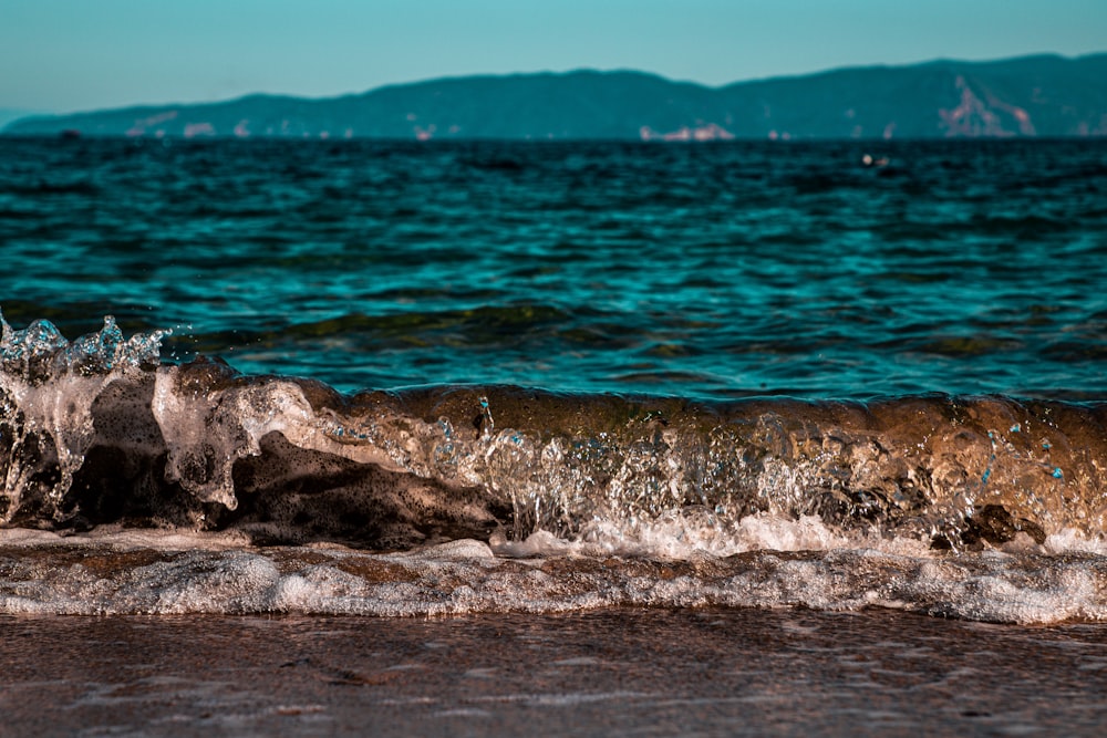 ocean waves crashing on shore during daytime