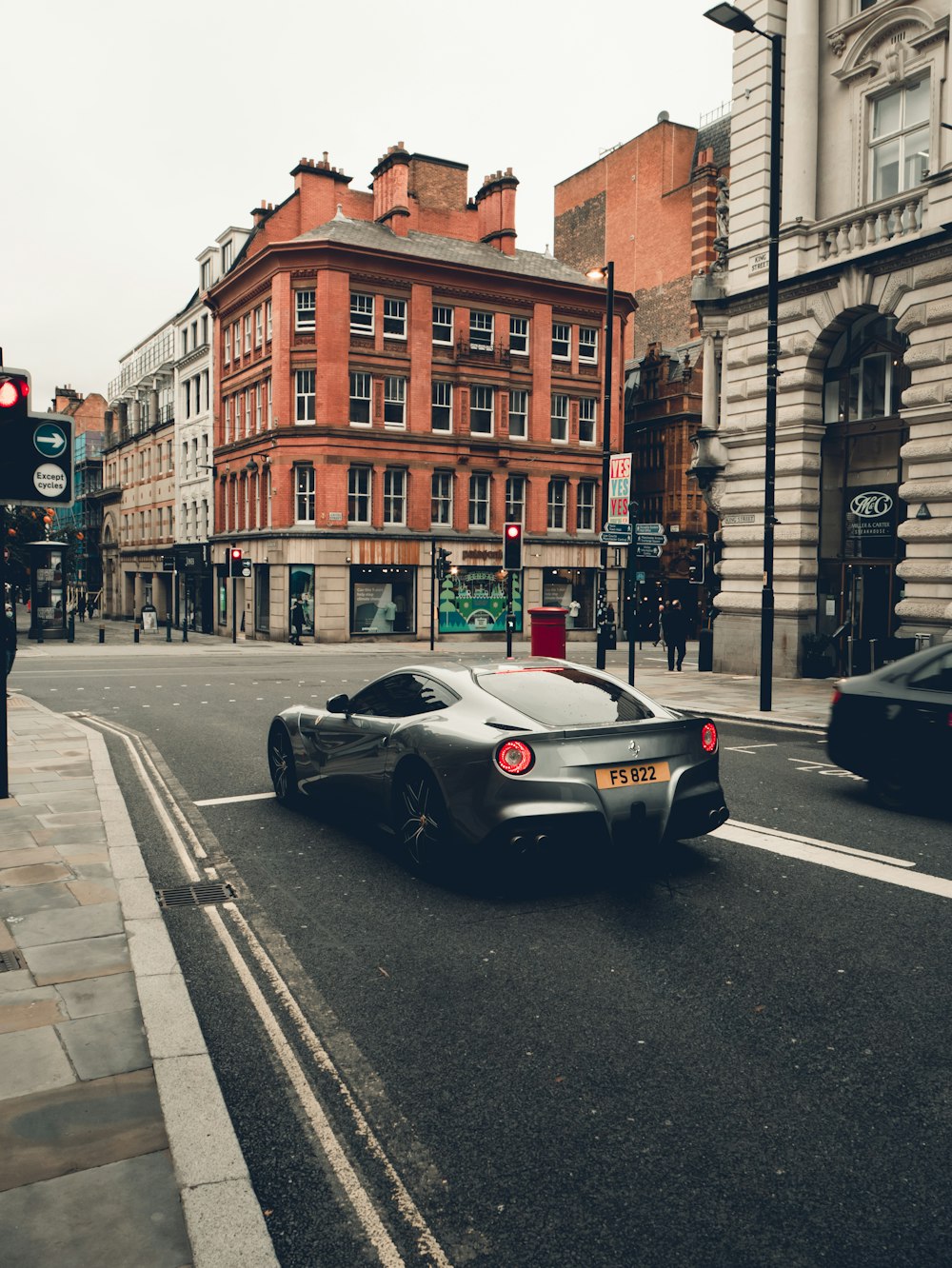 Porsche 911 negro en la carretera cerca de un edificio de hormigón marrón durante el día