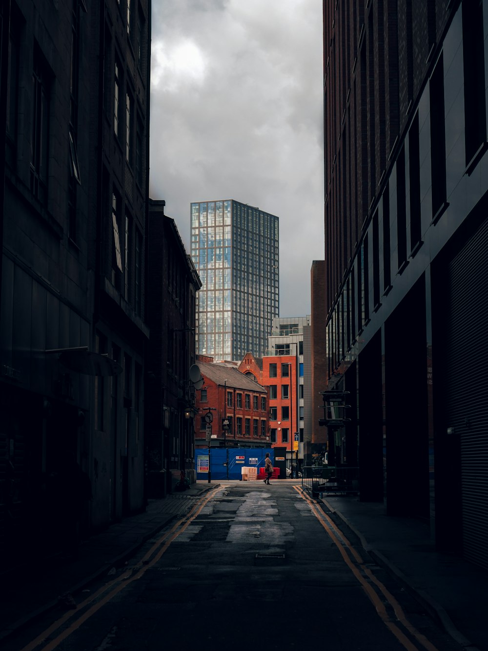 cars parked on side of the road in between buildings