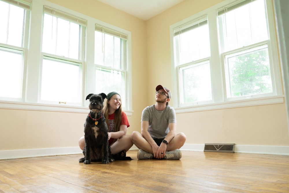 woman in gray shirt sitting on brown wooden floor