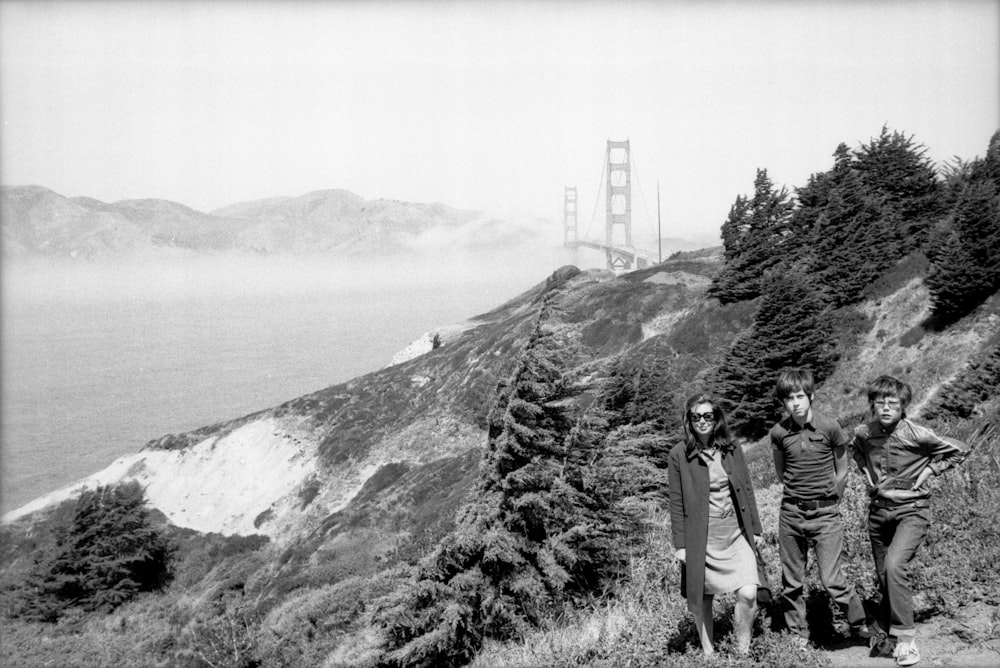 grayscale photo of man and woman kissing on mountain