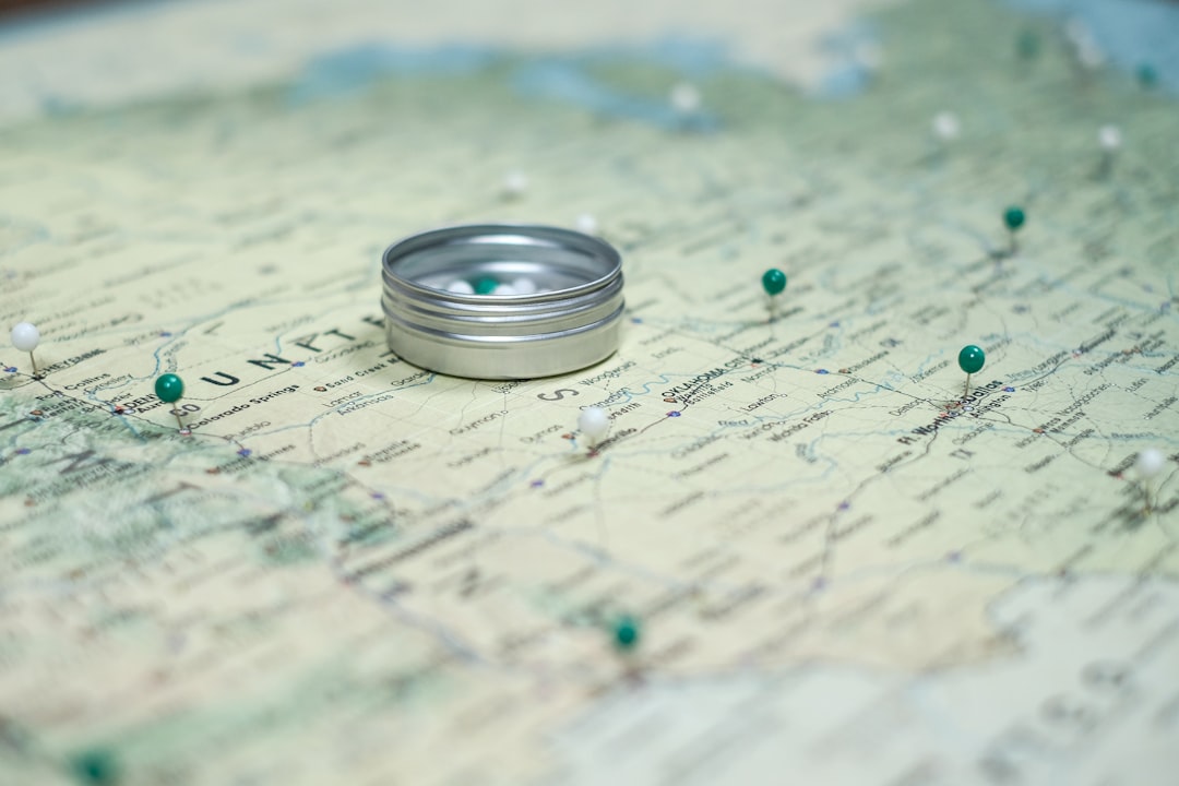 silver ring on white and blue textile, 📍 USA map ("Gulf Stream") with push pins closeup for travel tracking by Pin Adventure Map