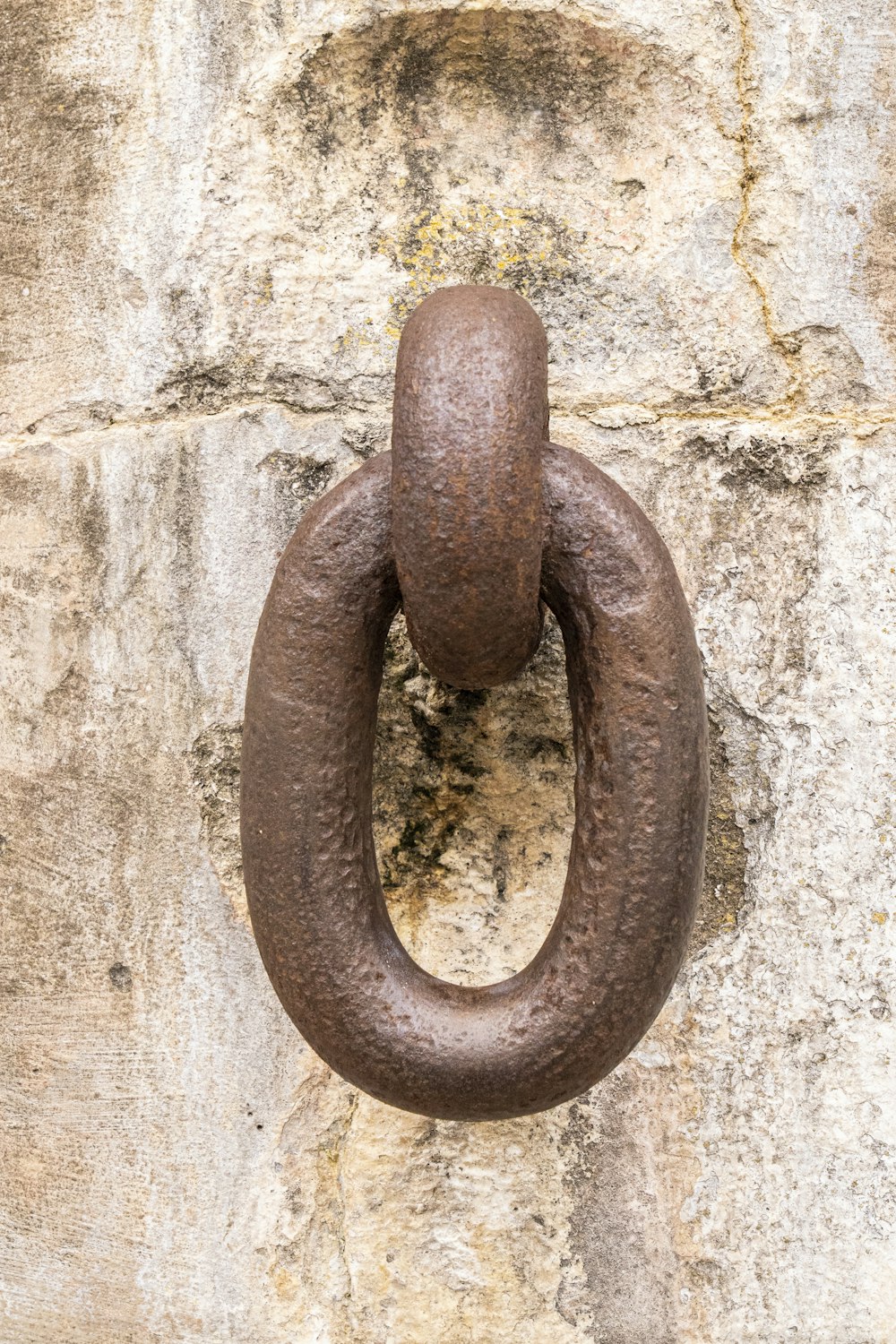 brown metal chain on white concrete wall