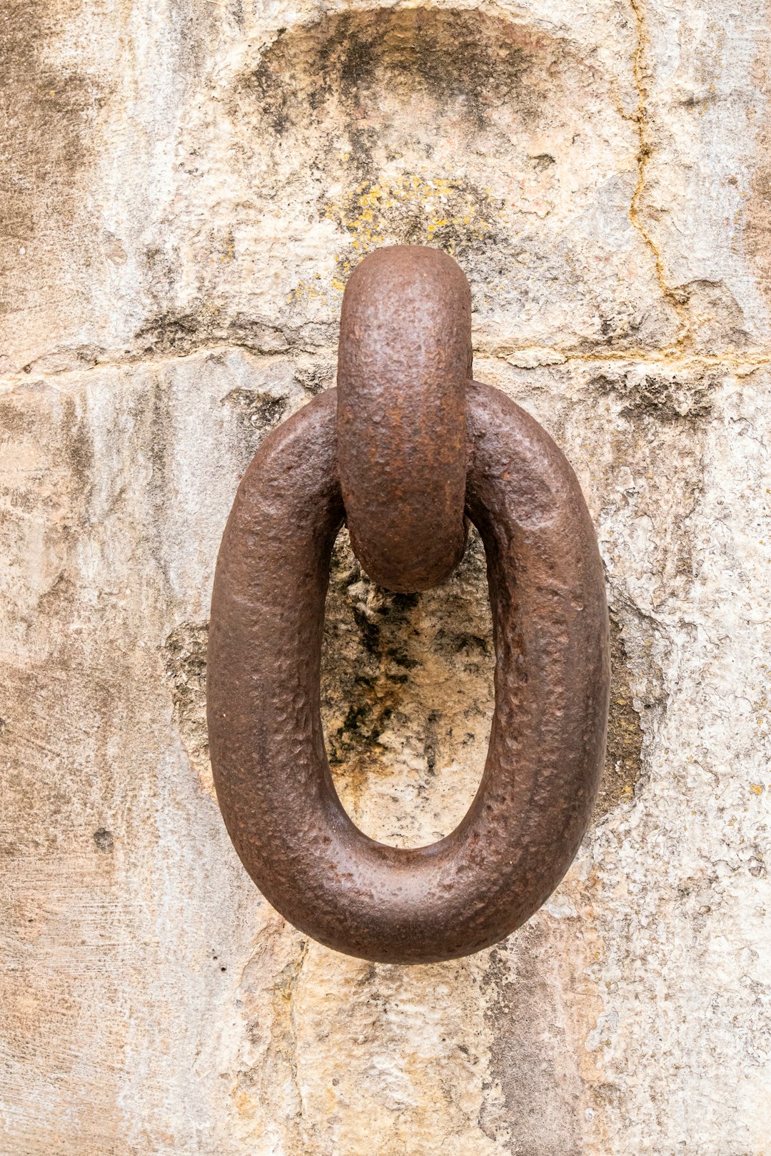brown metal chain on white concrete wall