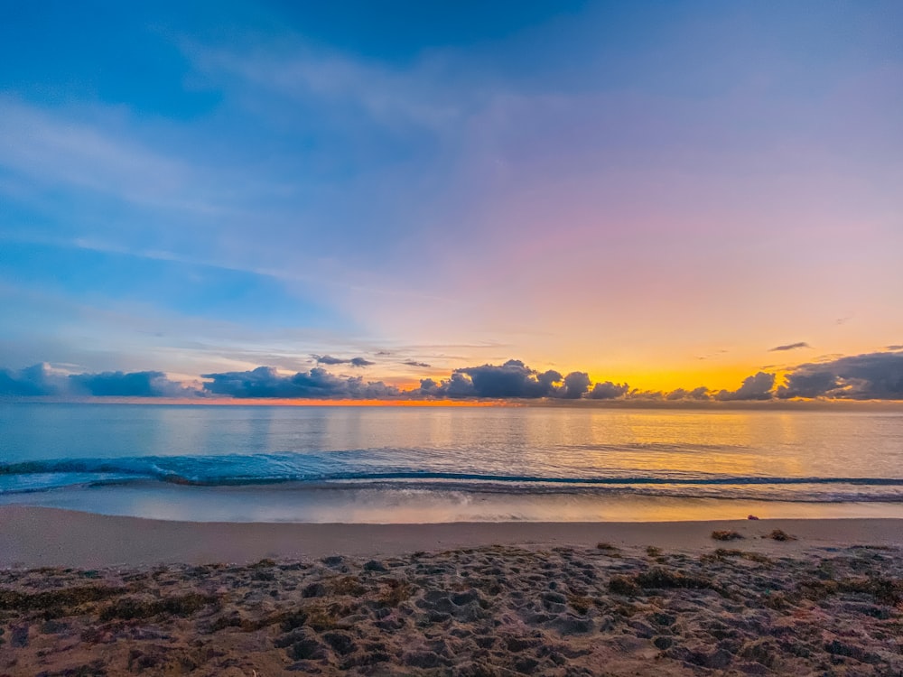 body of water under blue sky during sunset