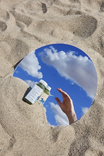 person holding green and white plastic bottle on blue round plate
