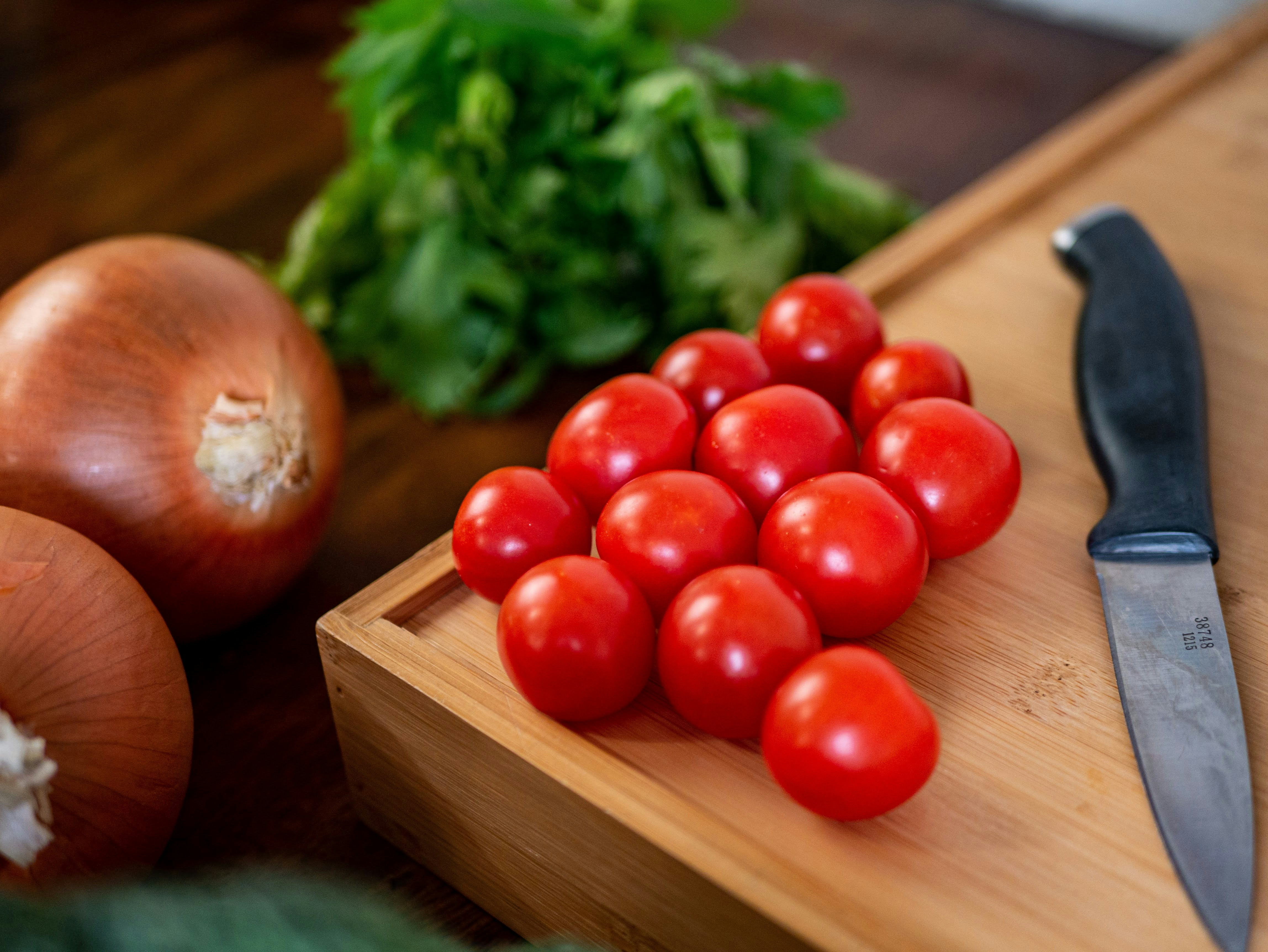 red tomatoes on brown wooden chopping board