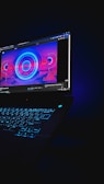 A vibrant digital download icon glowing on a laptop screen.
