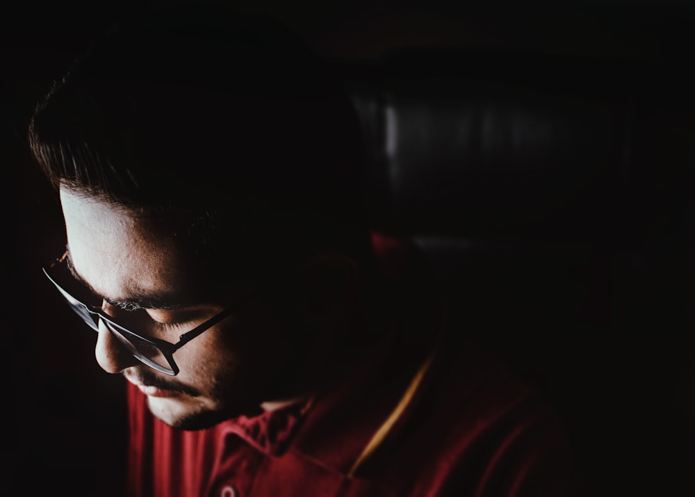 man in red shirt wearing black framed eyeglasses