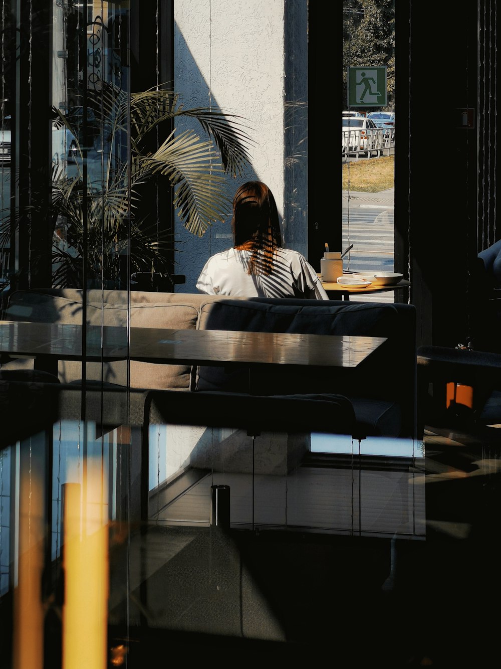 man in white and black stripe shirt sitting on brown wooden bench