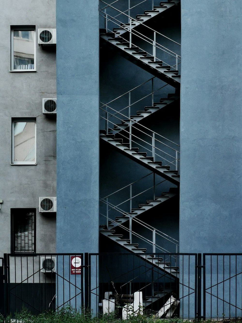 blue concrete building with white metal railings