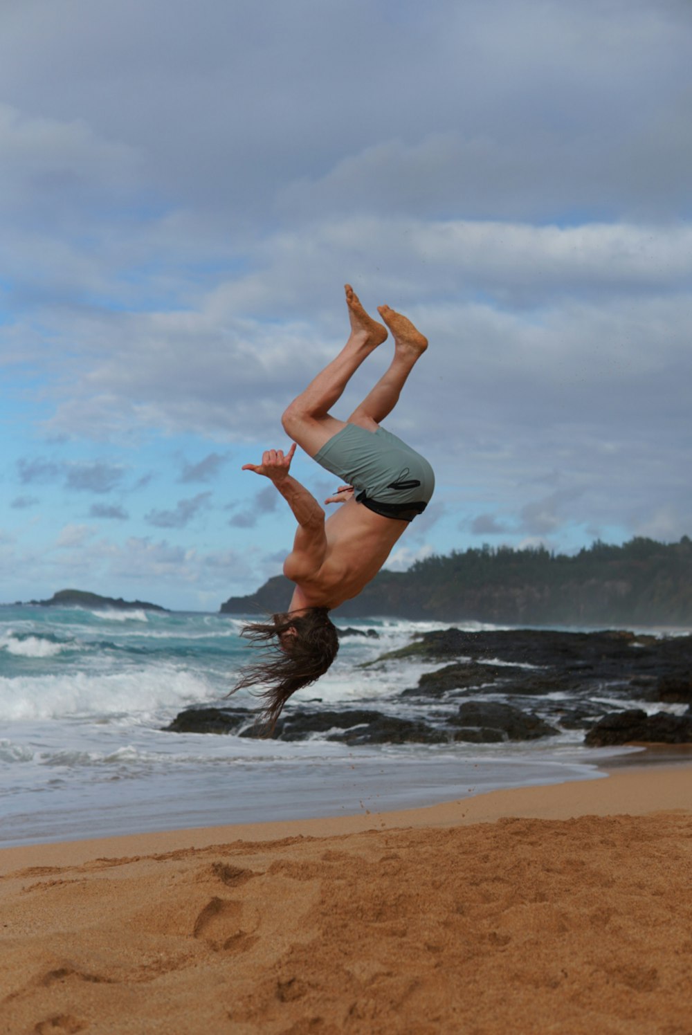 woman in black tank top and black shorts doing yoga on beach during daytime