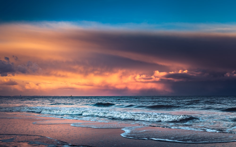 ocean waves crashing on shore during sunset