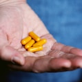 yellow medication pill on persons hand