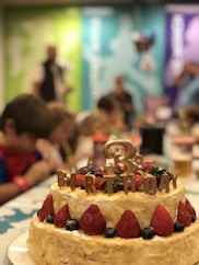 A joyful birthday cake surrounded by happy children.