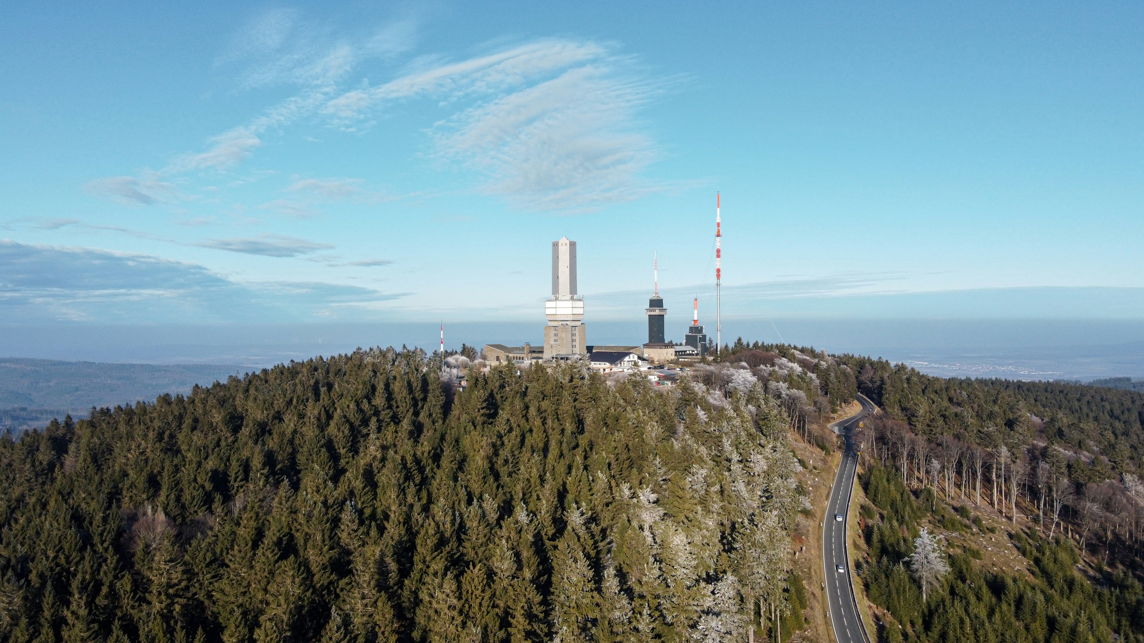 white and red tower near green trees under blue sky during daytime