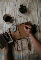 Close-up of hands holding a notebook with angelic symbols and golden highlights.
