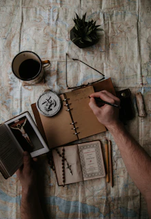 Close-up of hands holding a notebook with angelic symbols and golden highlights.
