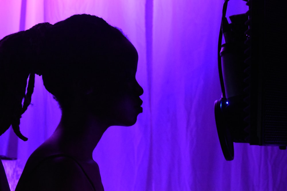 silhouette of woman standing near pink curtain