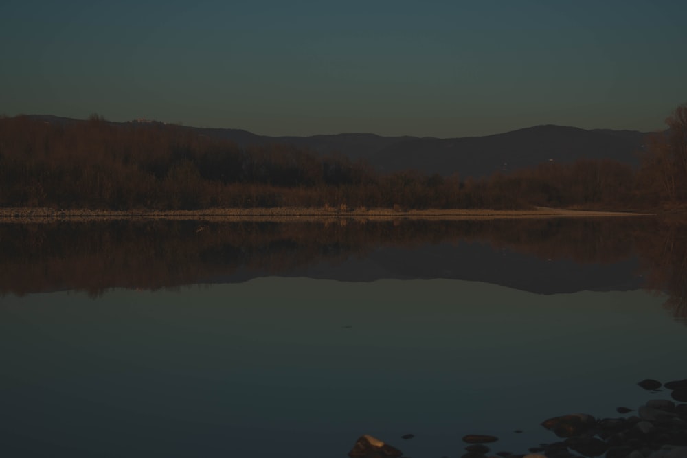 body of water near mountain during daytime