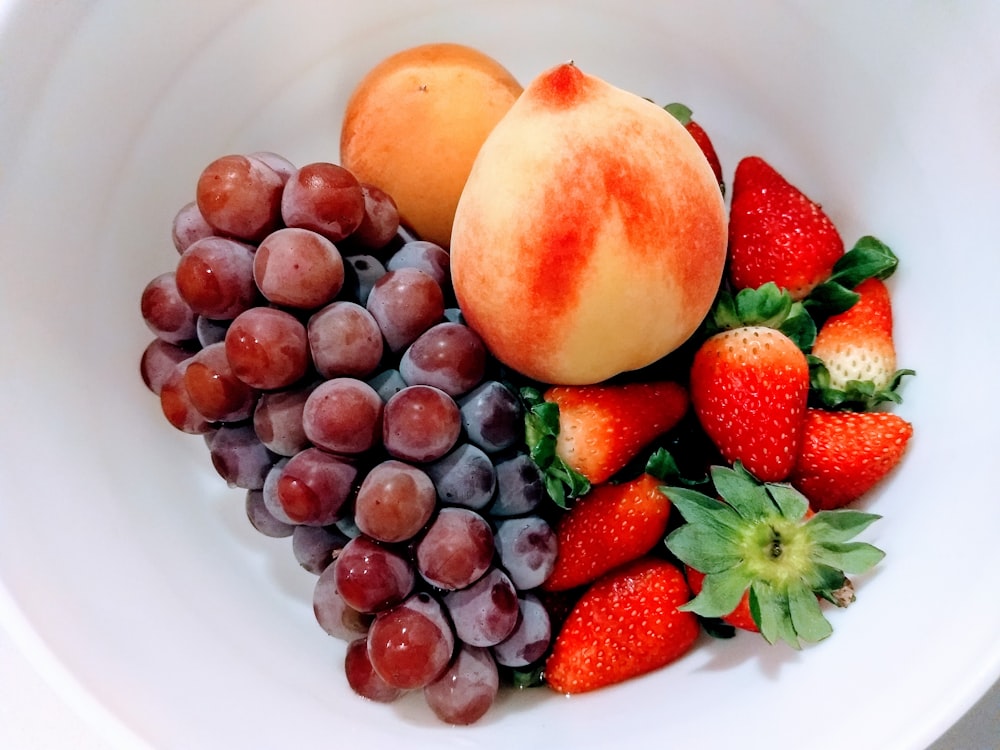 red and black berries on white ceramic plate