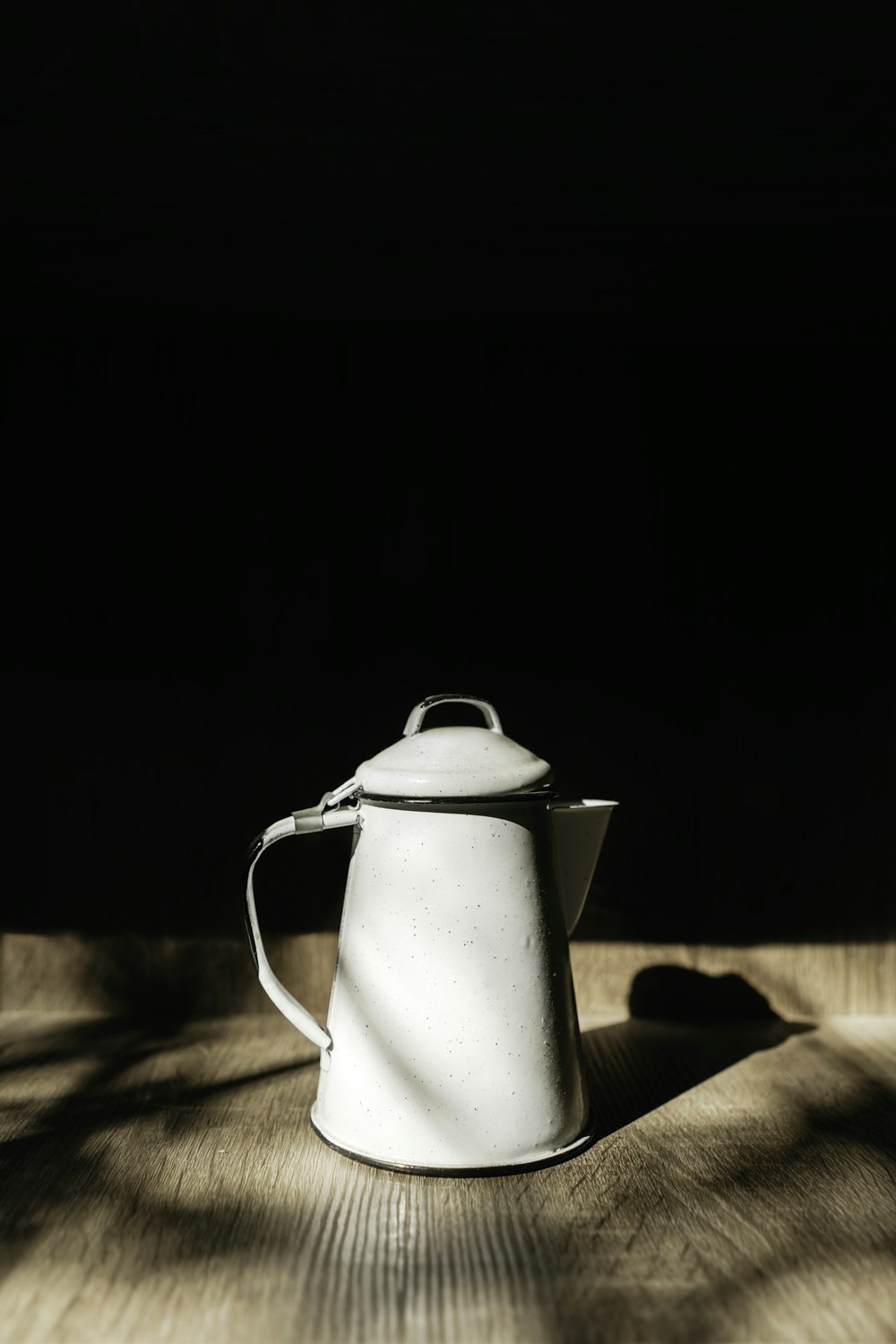 stainless steel pitcher on brown wooden table