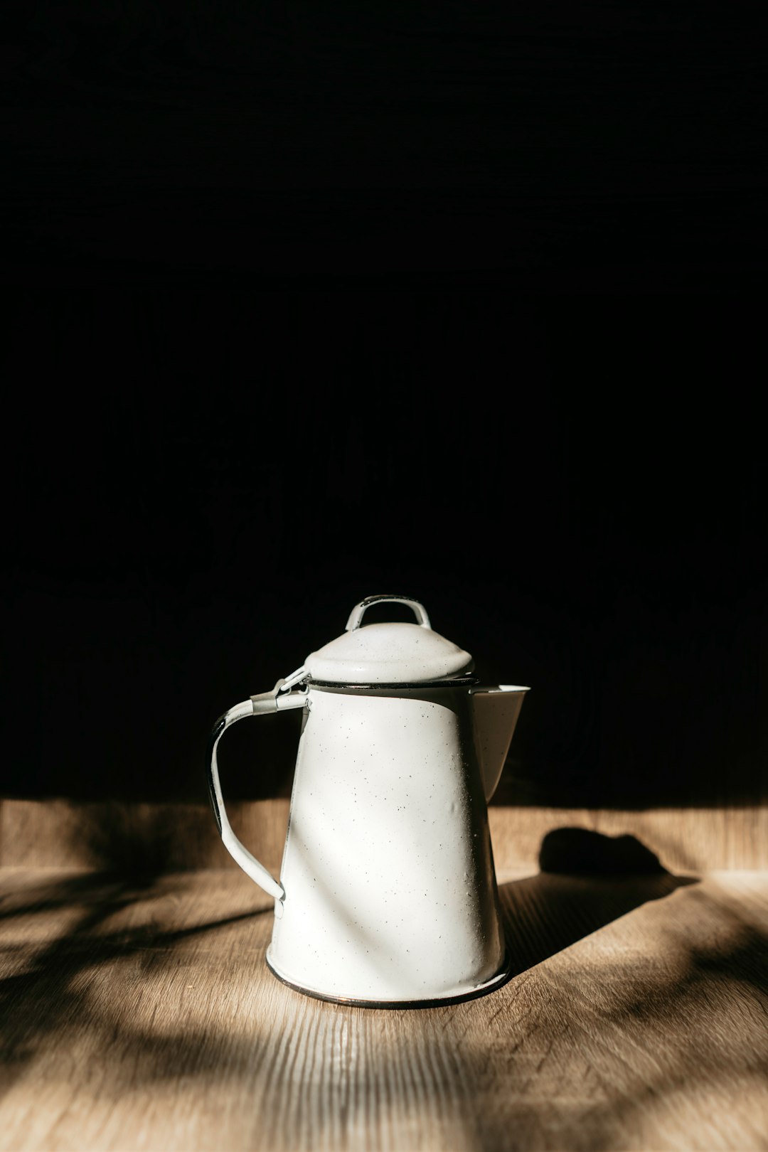 stainless steel pitcher on brown wooden table