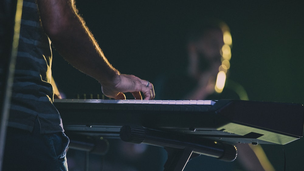 person holding black and white electronic keyboard