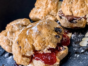 Close-up of golden chocolate chip cranberry scones with a dusting of powdered sugar