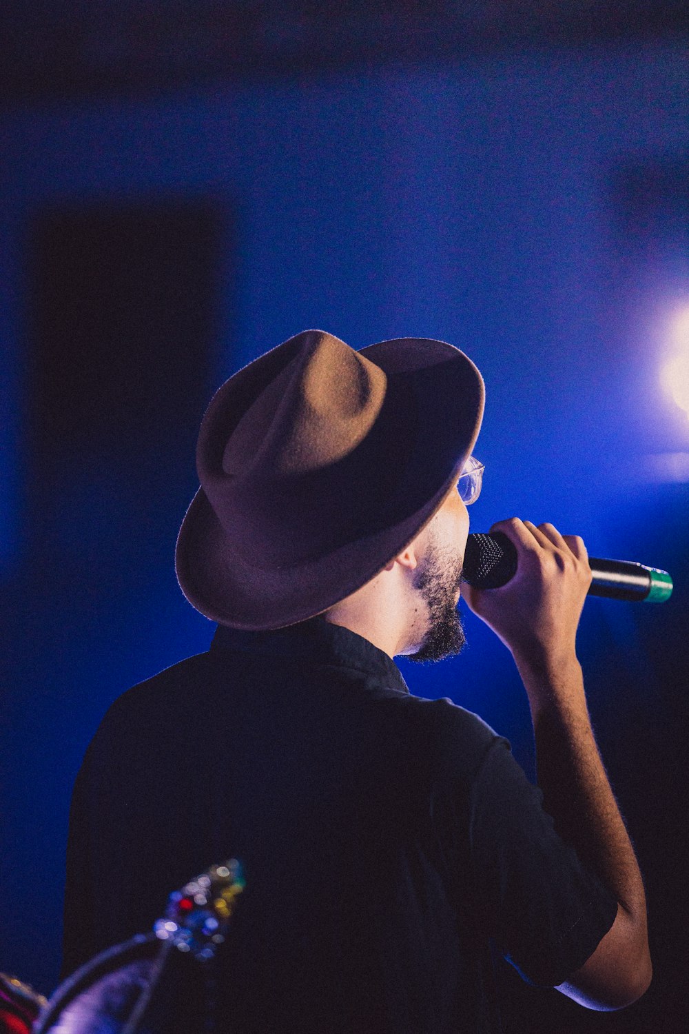 man in black shirt wearing brown cowboy hat singing