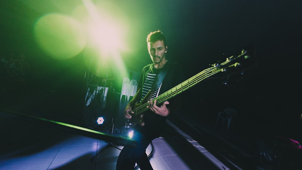 man in black and white striped shirt playing guitar