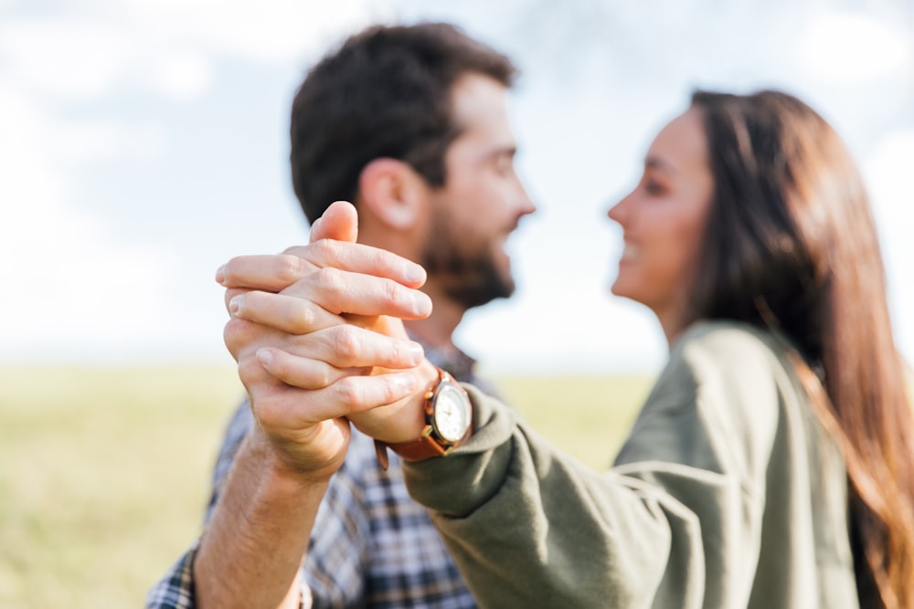 man in gray long sleeve shirt holding womans hand