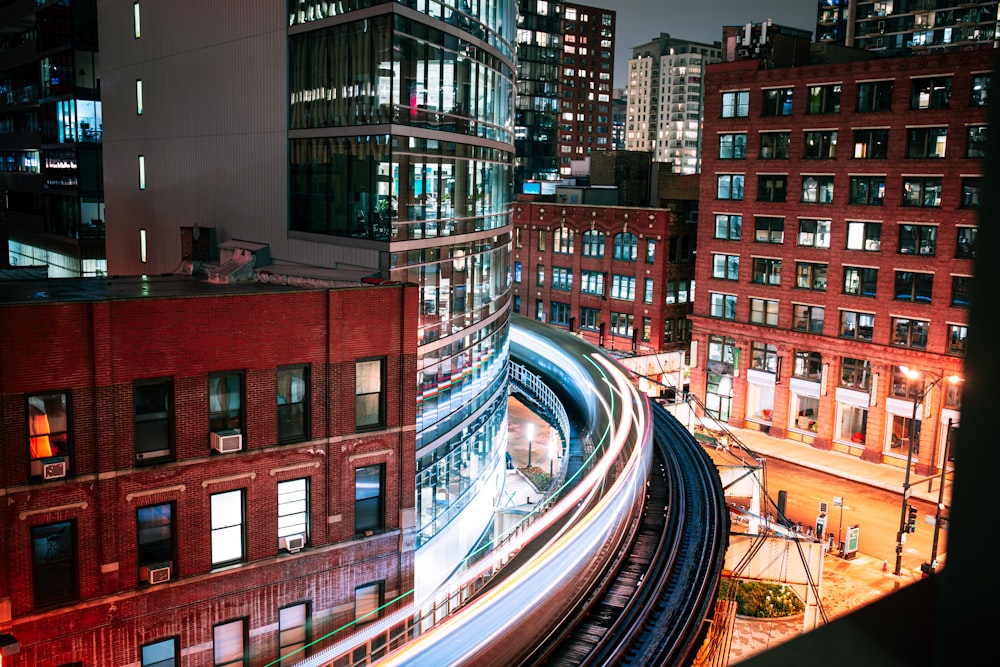 time lapse photography of cars on road near buildings during night time