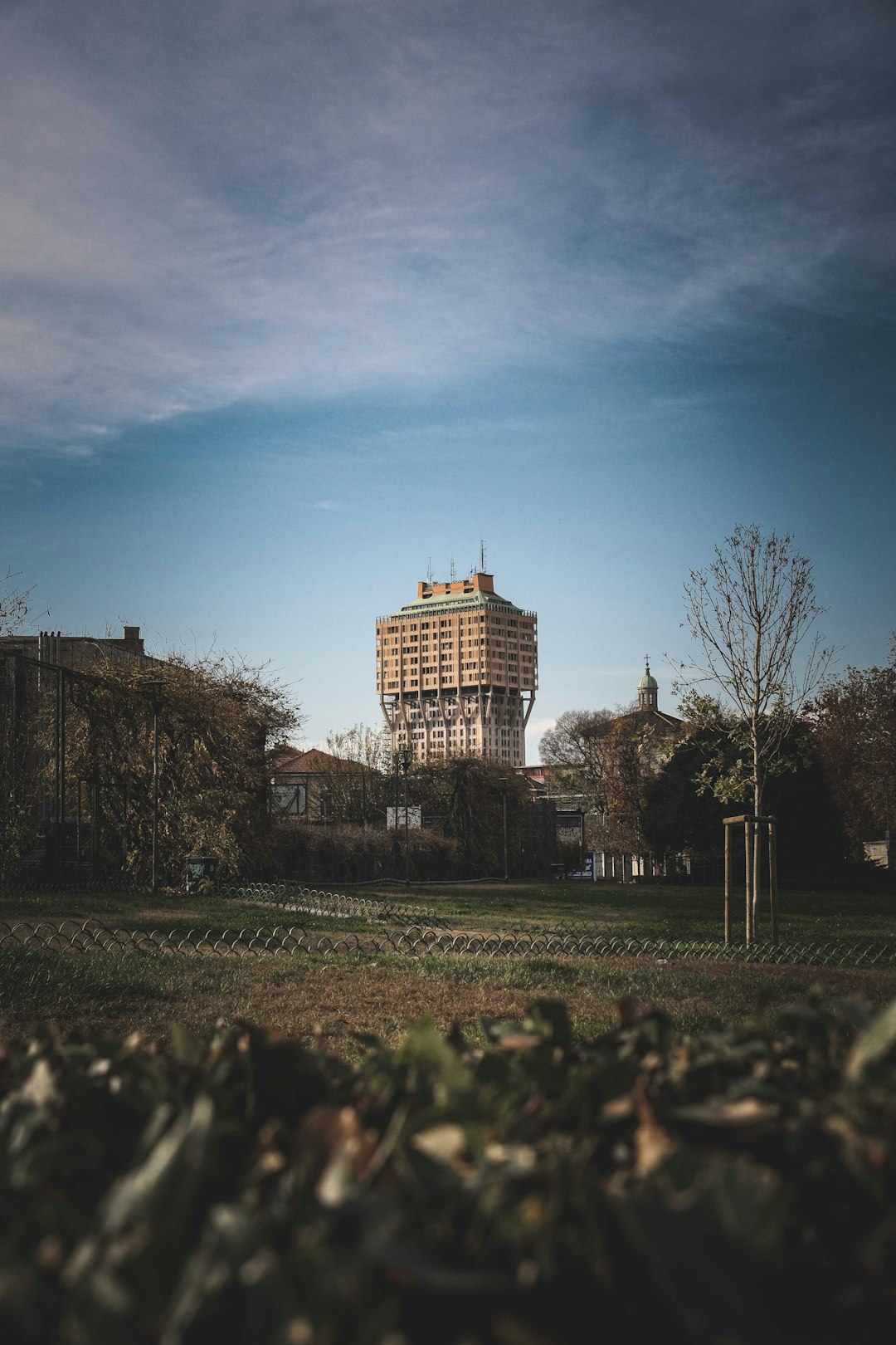 brown concrete building near trees under blue sky during daytime