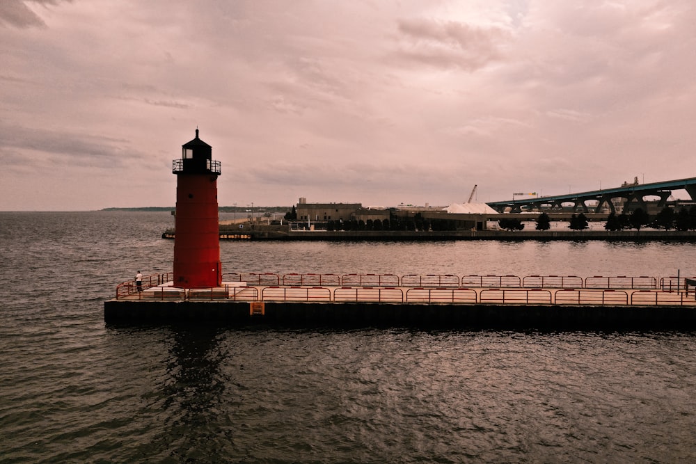 red and white lighthouse near body of water during daytime