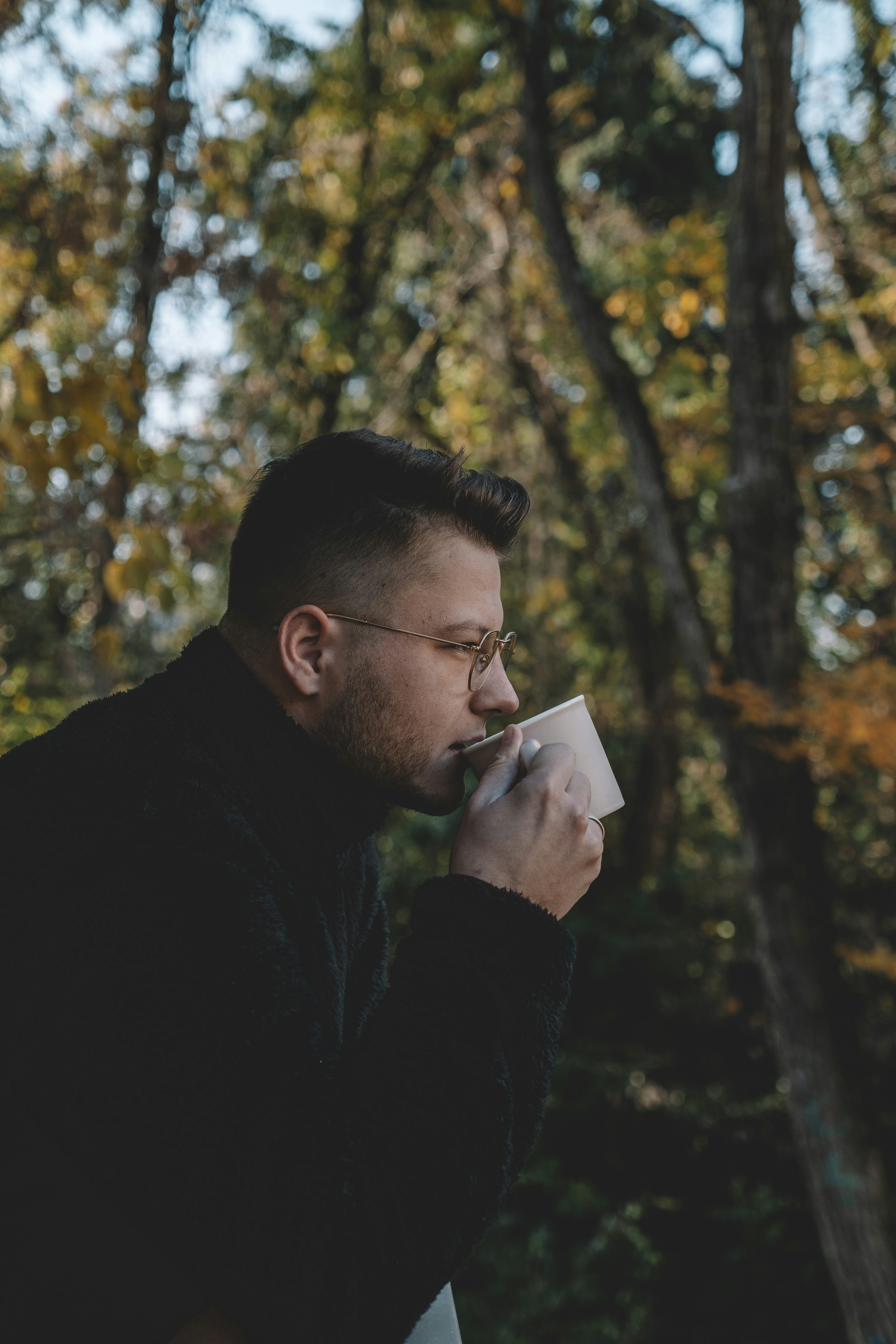 man in black sweater holding book