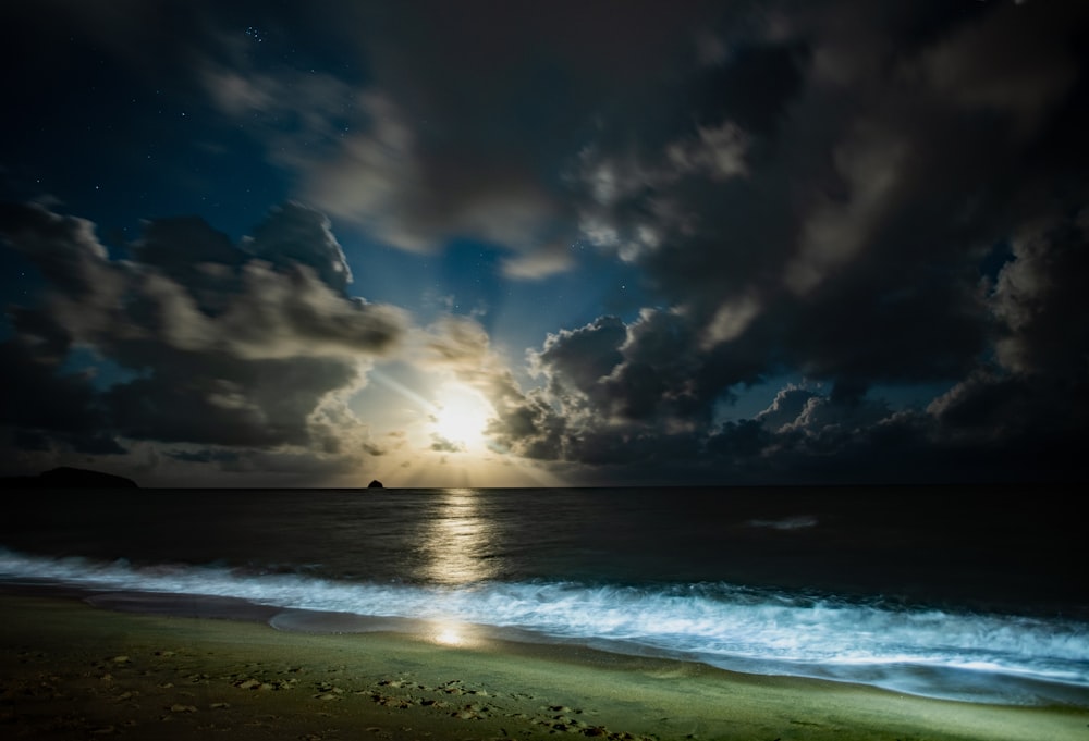 sea waves crashing on shore under blue and white cloudy sky during daytime