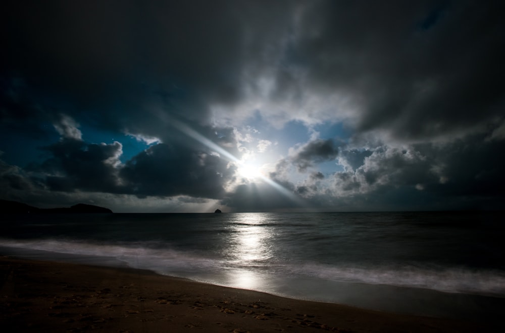 sea waves crashing on shore under blue and white cloudy sky during daytime