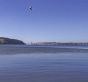 A scenic view of the Bosphorus Bridge connecting two continents under a clear blue sky.