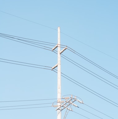 brown electric post under blue sky during daytime