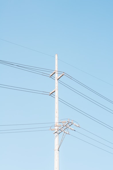 brown electric post under blue sky during daytime