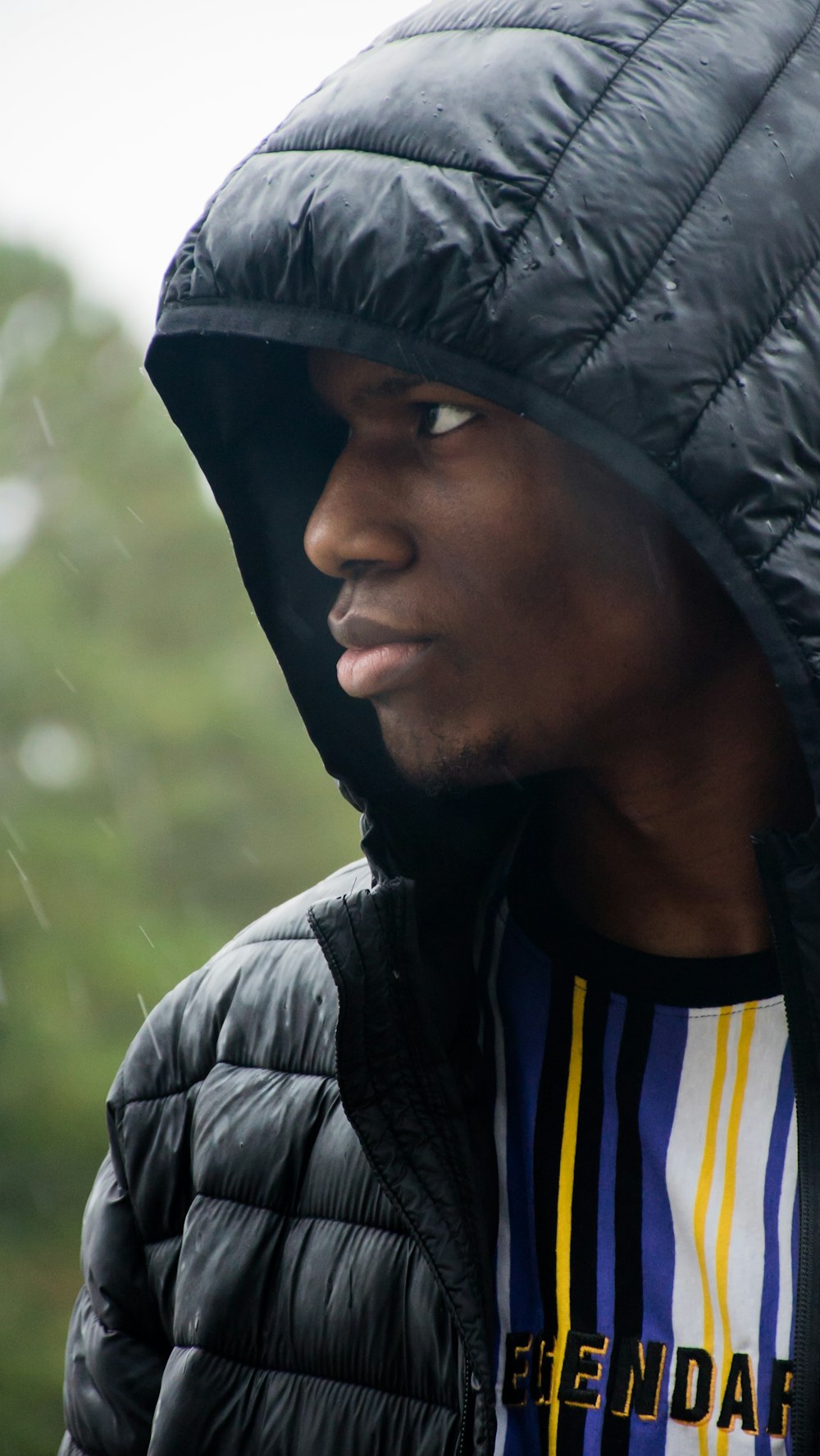 man in black and yellow adidas shirt wearing gray hoodie