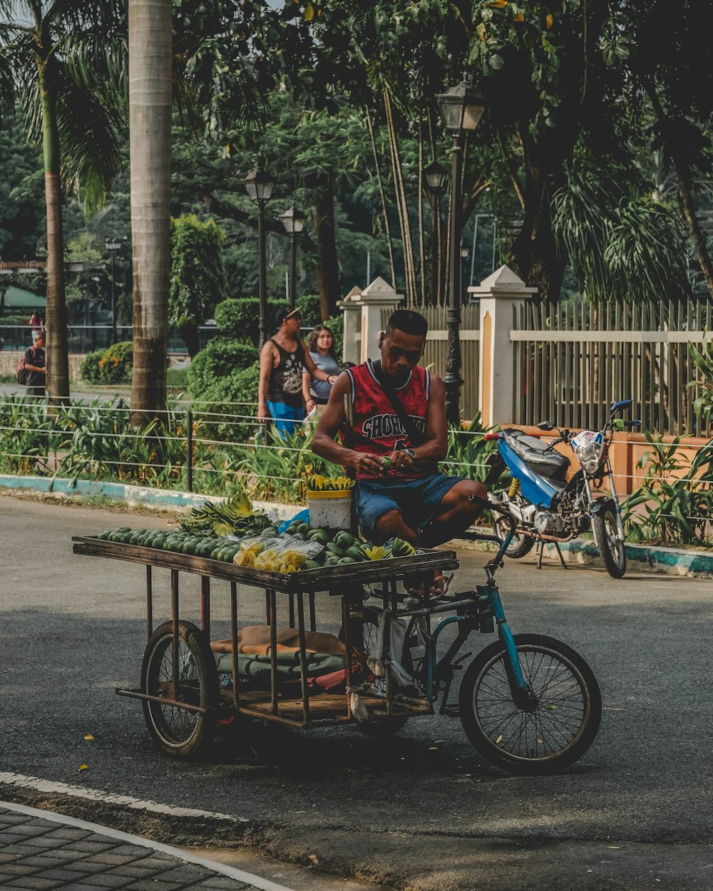 man in blue and red shirt riding on blue bicycle during daytime