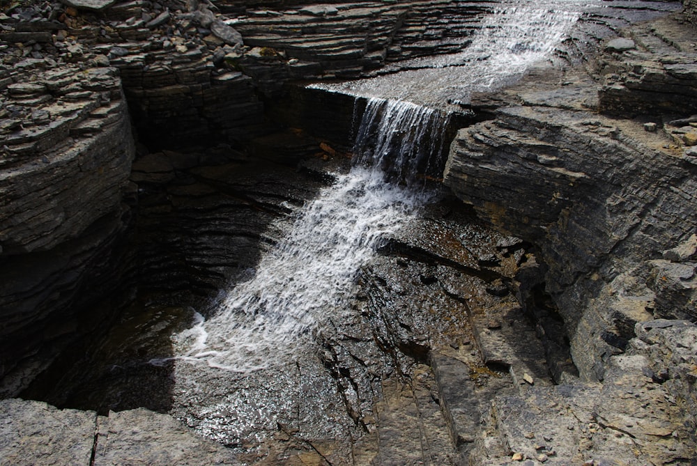 water falls on brown rocky mountain