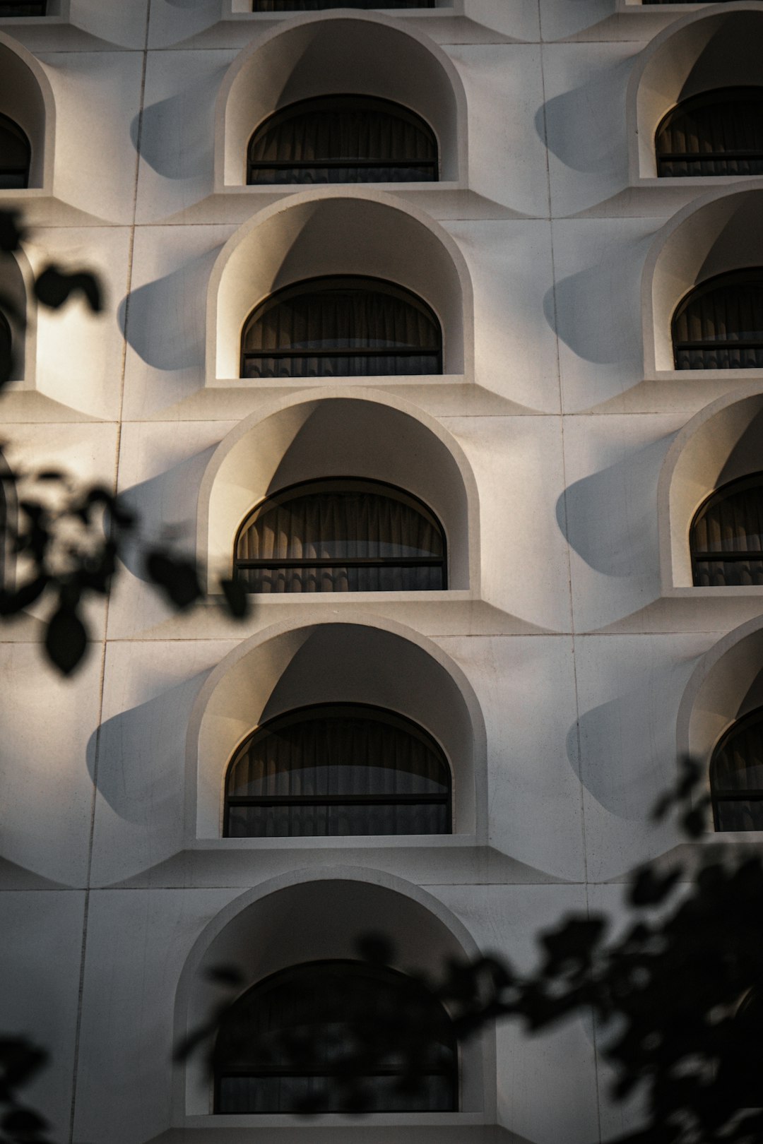 white concrete building with black metal chandelier