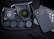 A collection of phone camera accessories is neatly arranged. A black phone case and multiple camera lens attachments are visible. Each lens is in its individual compartment inside a black zippered case. A digital device with a keyboard is partially visible.